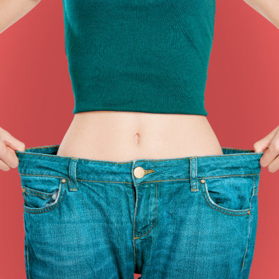 Woman with too large jeans showing off her weight loss